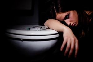 woman with head against toilet bowl, how to tell if someone is on heroin