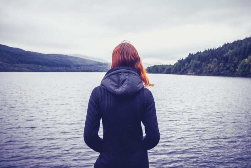 depressed woman staring at lake