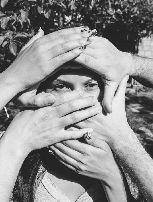 Hands covering woman's face.