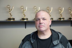 Shawn Rech in front of emmy awards