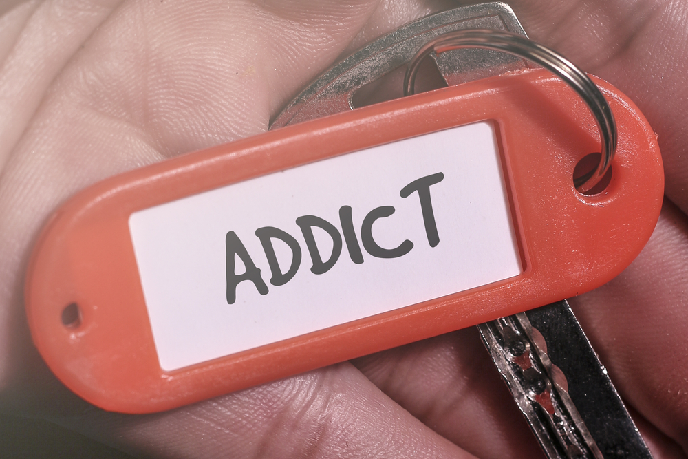 A keychain with the word ADDICT written on it.
