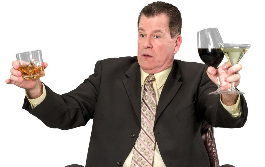 A man holding a few alcoholic drinks.