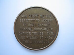 A metal coin with the serenity prayer on it
