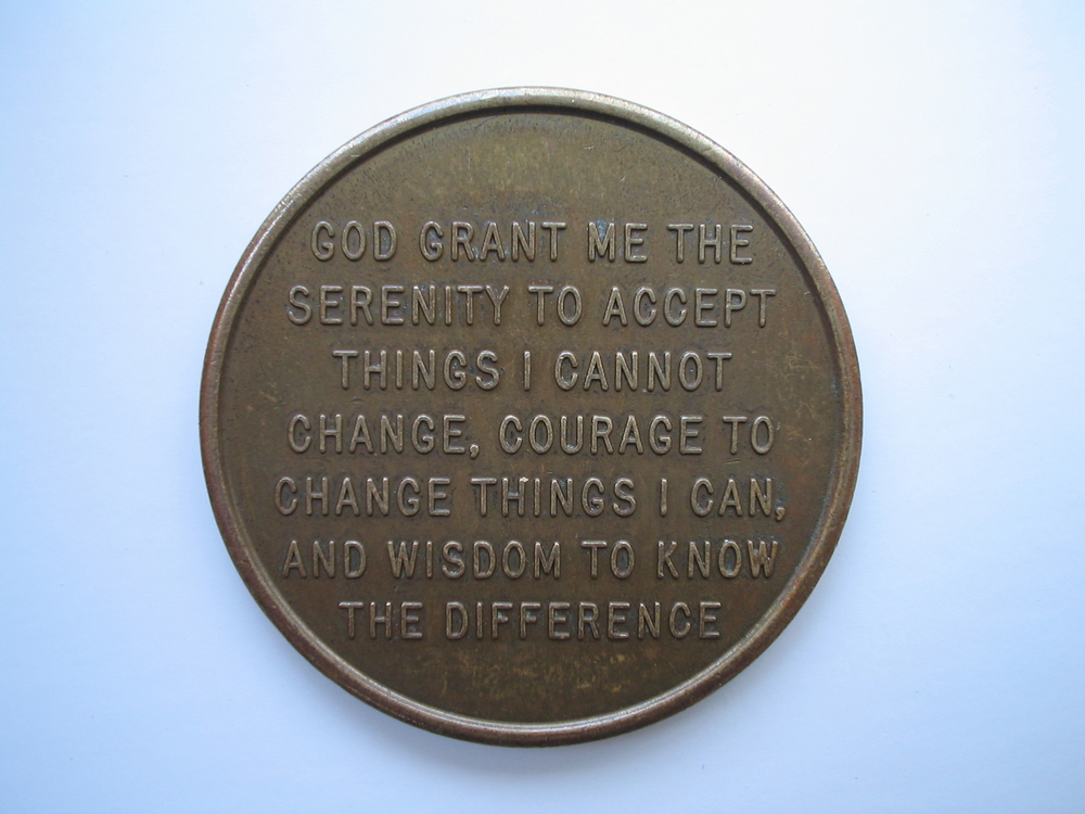 A metal coin with the serenity prayer on it