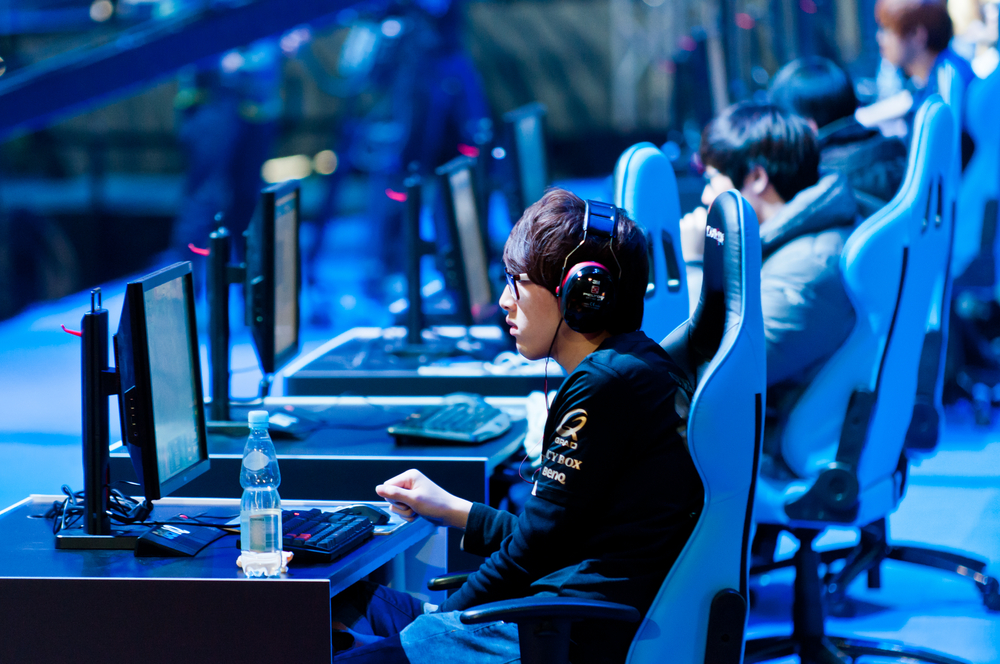 A gamer at a computer wearing headphones.