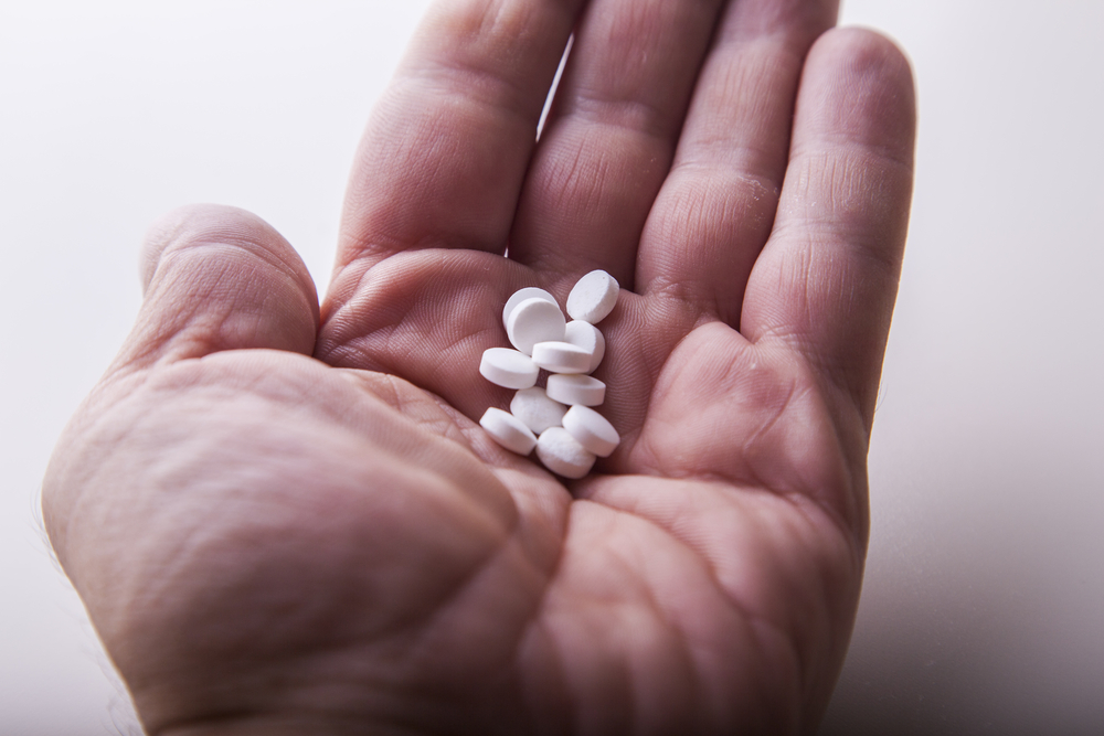 A hand holding naltrexone pills