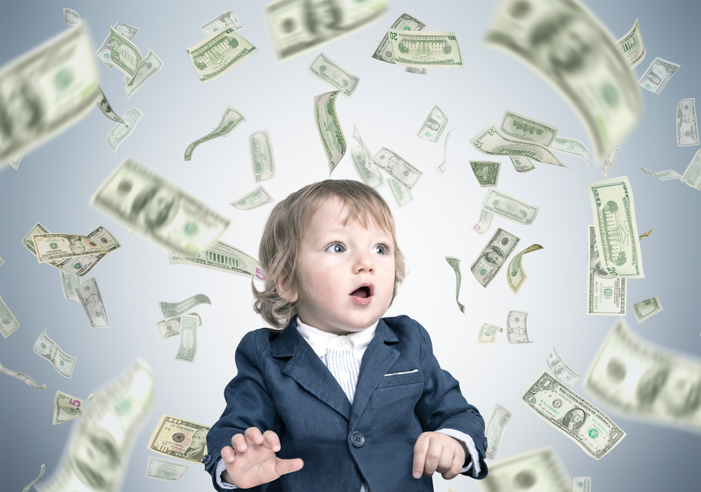 A child surrounded by flying dollar bills.