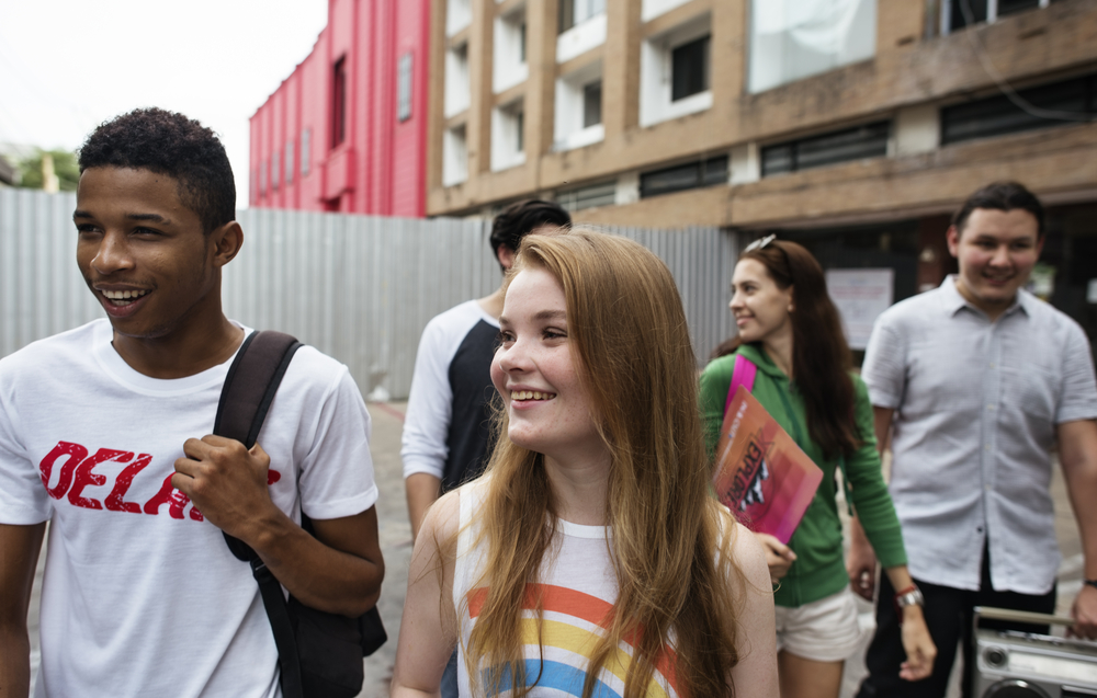 A group of teens walking together and smiling.