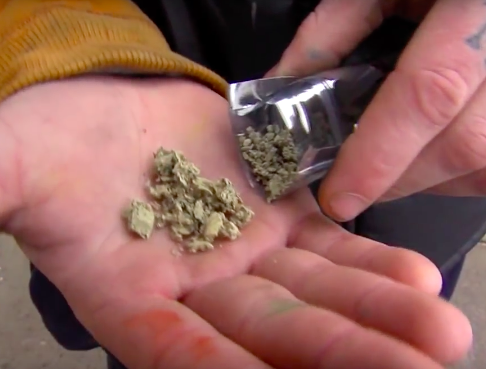 Man pouring synthetic marijuana into his hand.