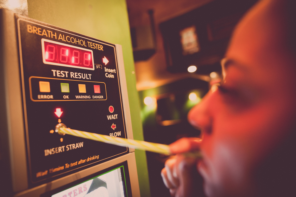A woman takes an alcohol breath test.