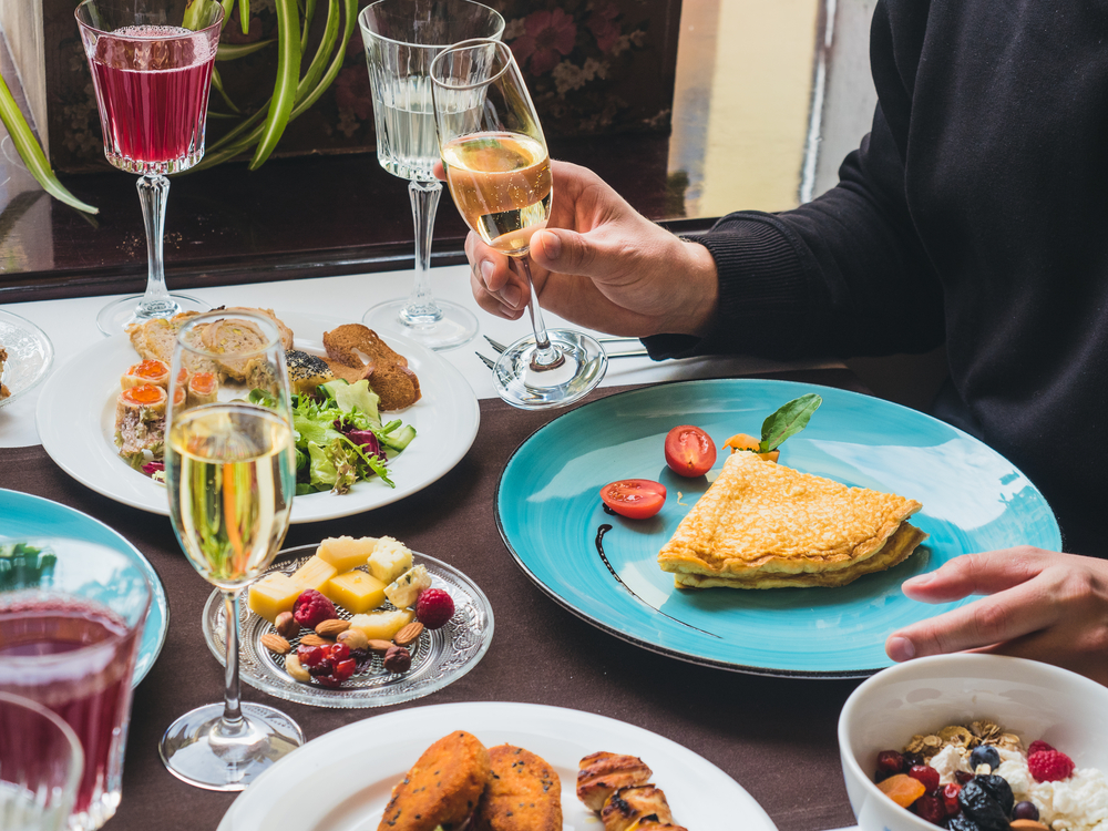 plates of breakfast foods and a man holding a champagne glass.