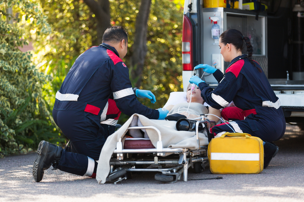 EMTs rescuing a patient outside of an ambulance.