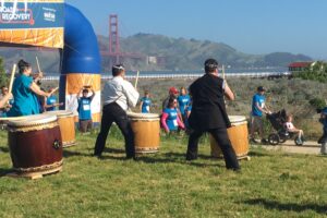 people running marathon with drummers in foreground