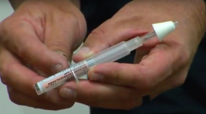 person holding a narcan injector.