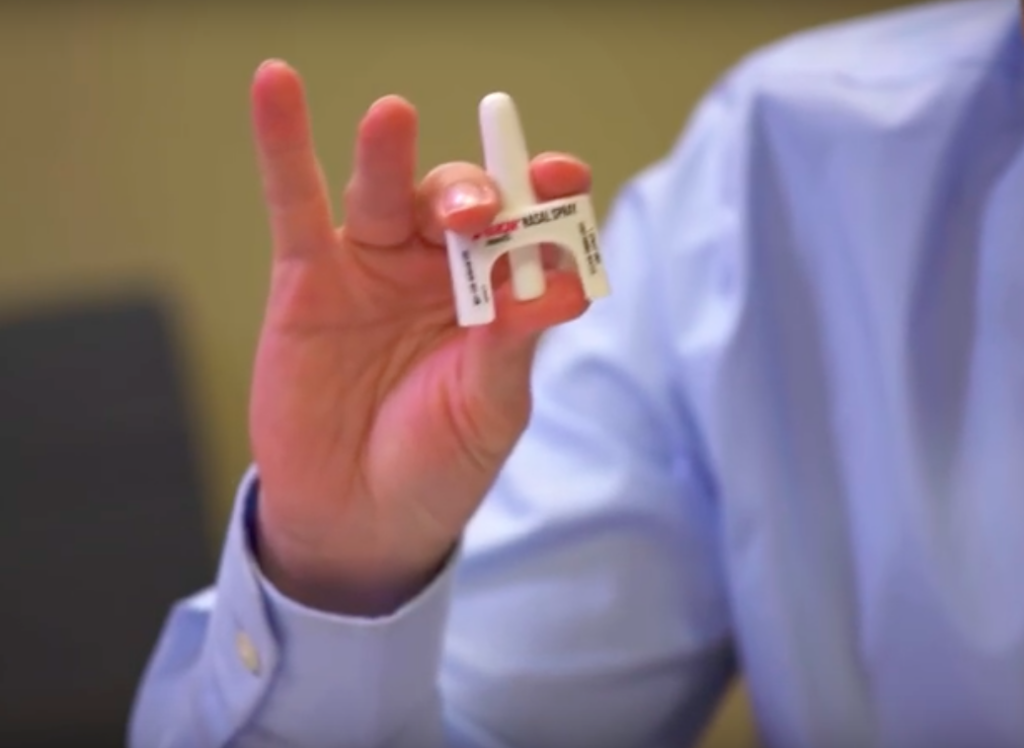 person holding a narcan injector.