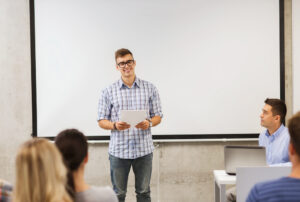 high school teen making a presentation in front of his class.