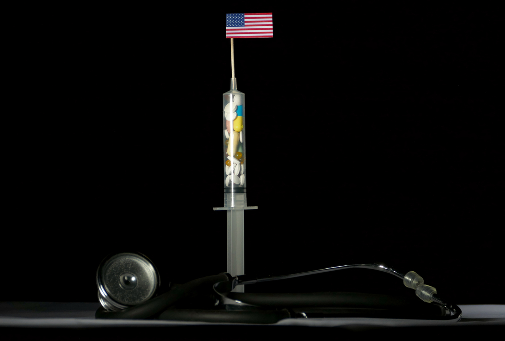 Syringe full of pills with American flag on top