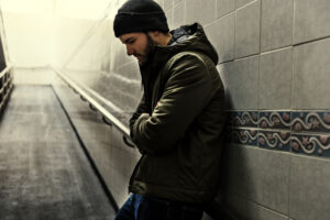Man leaning on wall looking down