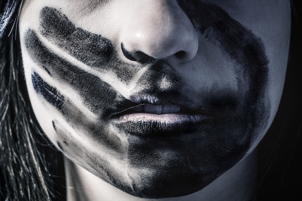 woman's face with palm print over mouth