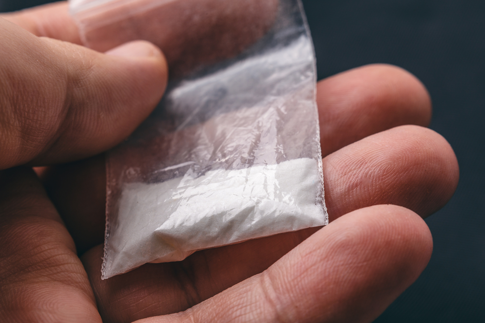 person holding a baggie of cocaine.