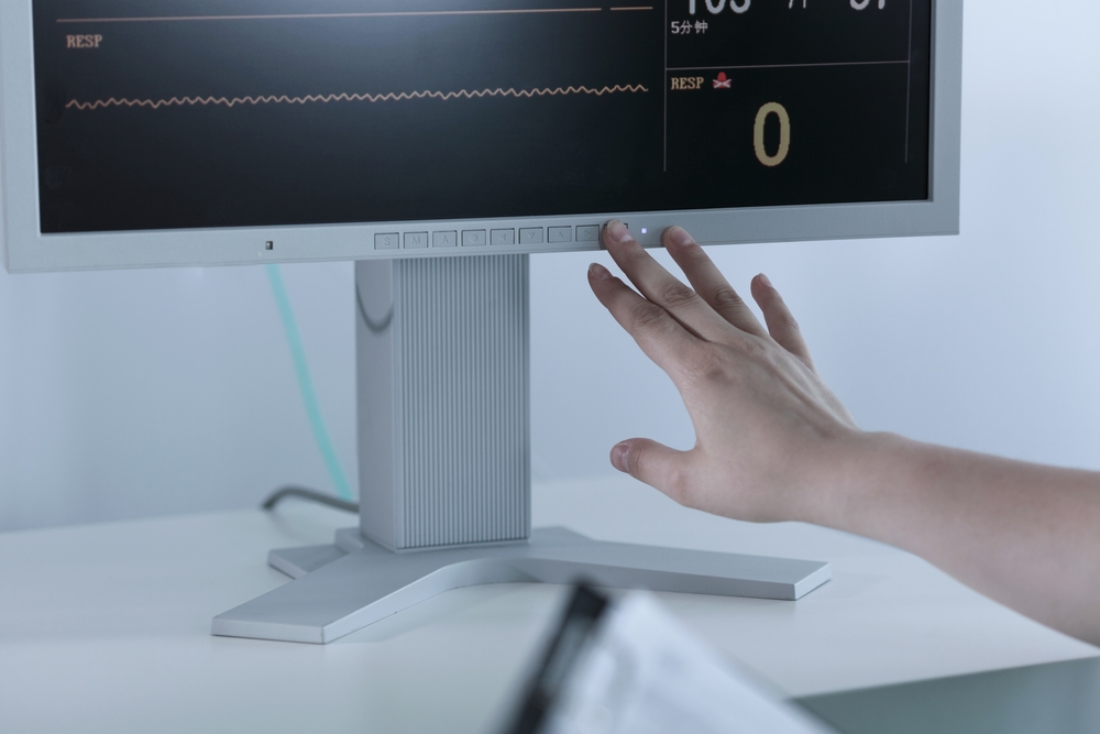 A hand turning off a flatlining electrocardiogram