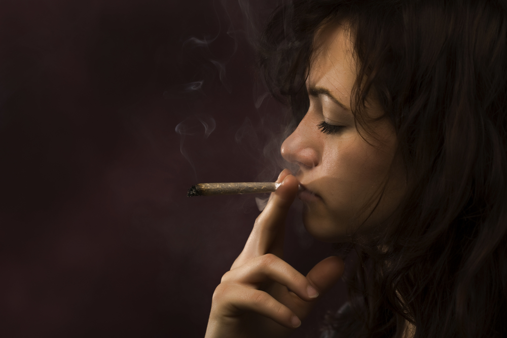 Woman smoking a marijuana joint.