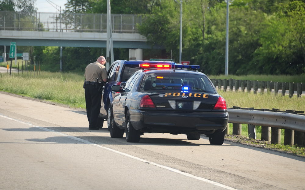 Police officer talking to a driver on the side of the road.