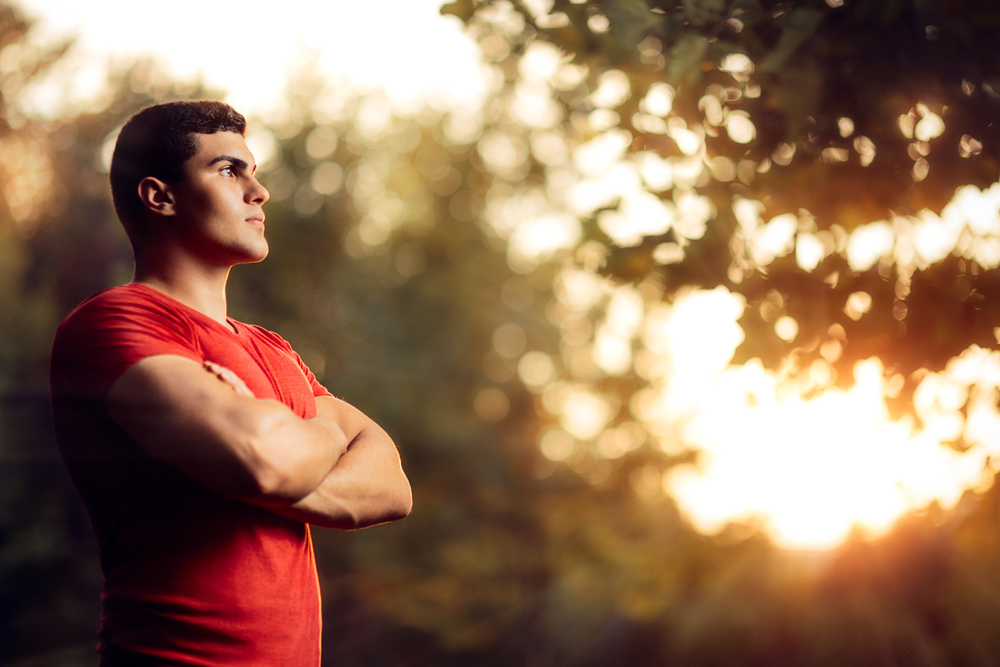 man wearing red shirt and crossing arms over chest