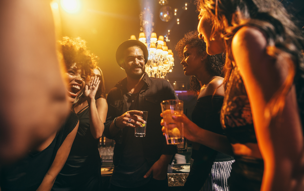 a group of people drinking in a club setting