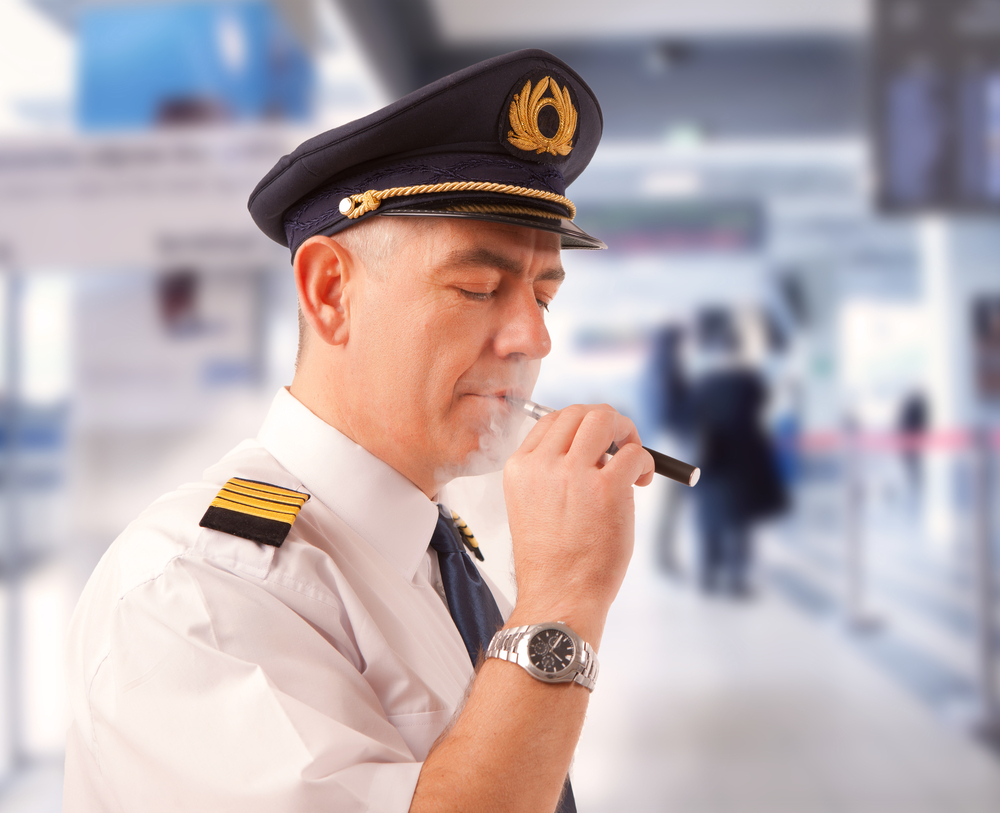 Airline pilot vaping an e-cigarette before a flight.