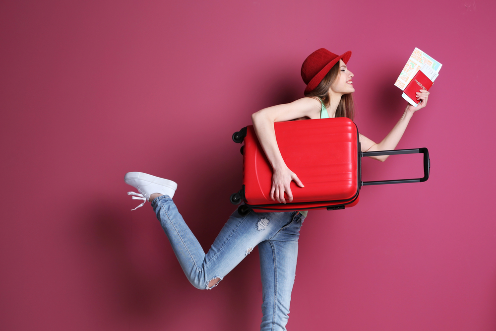 Female traveler holding suitcase and passport