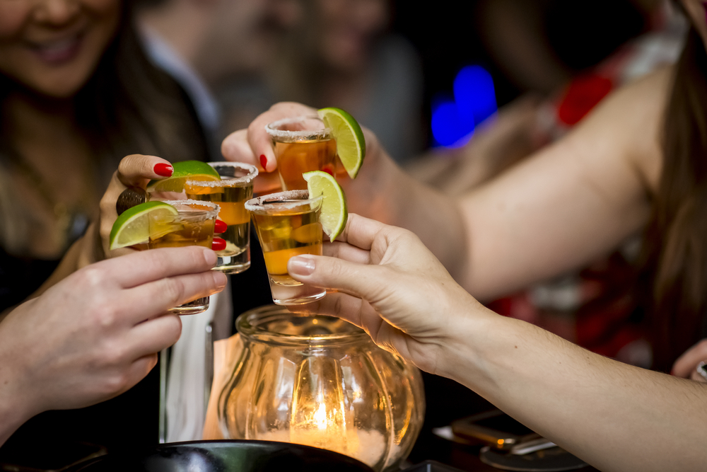 a group of women toasting with tequila shots