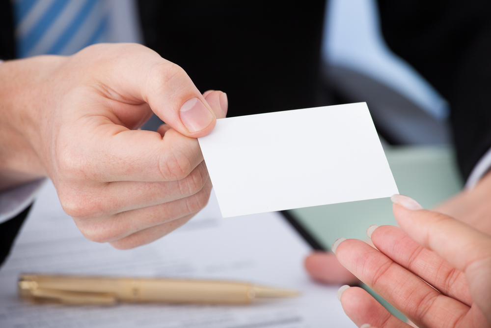 a person handing their business card to another person