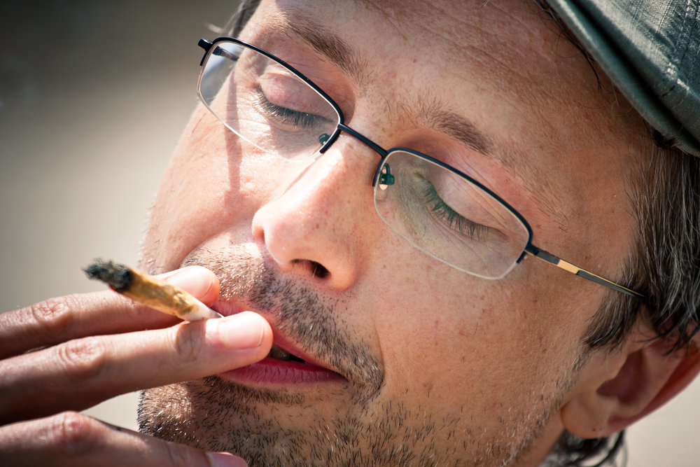 Man smoking marijuana outside free of worry.