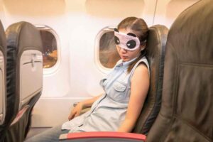 Woman sleeping with eye mask on plane