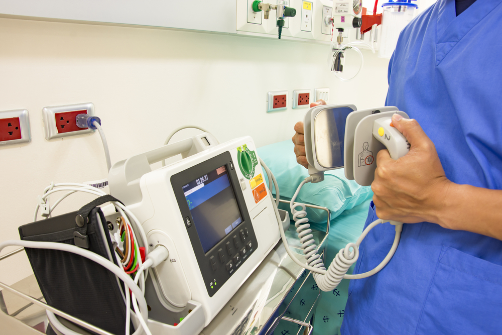 doctor use EKG or ECG and test defibrillator system in emergency room