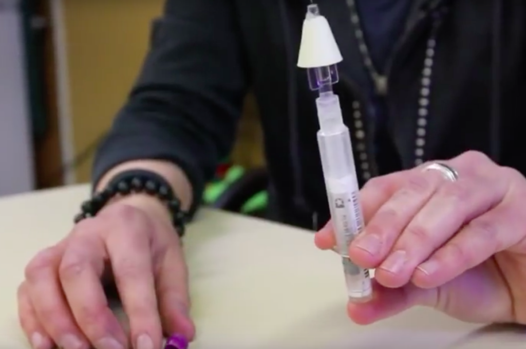 a woman holding naloxone nasal spray