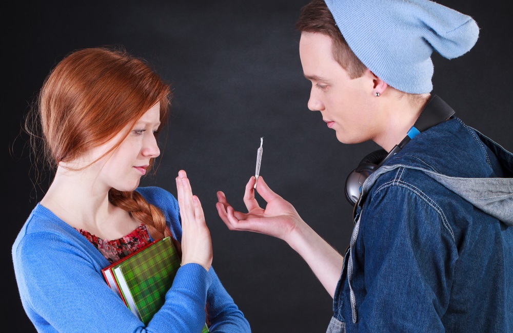 Teen girl rejects offer of marijuana from teen boy in high school.
