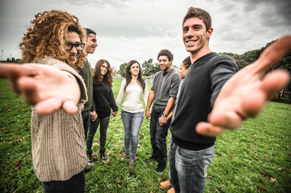 young adults holding hands and extending hands