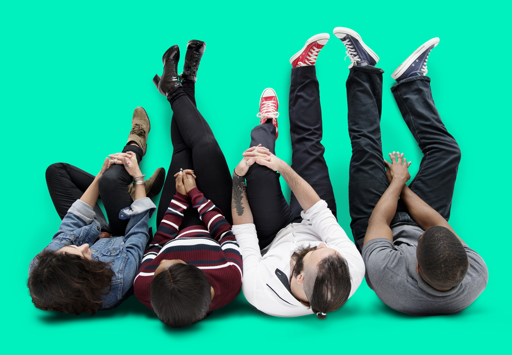 young adults sitting together with green backdrop