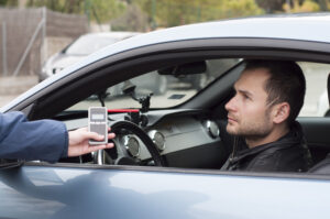 Driver being subjected to breathalyzer test.