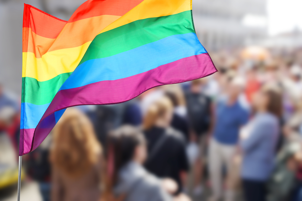 LGBTQ flag being waved in crowd of people