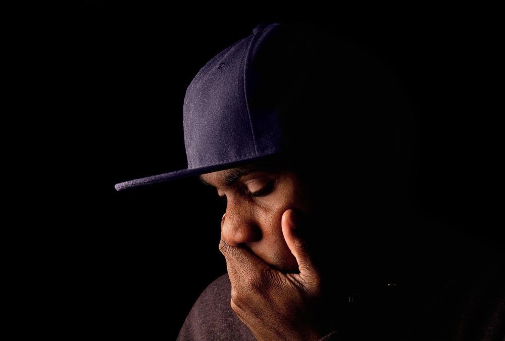 solemn black man wearing a hat