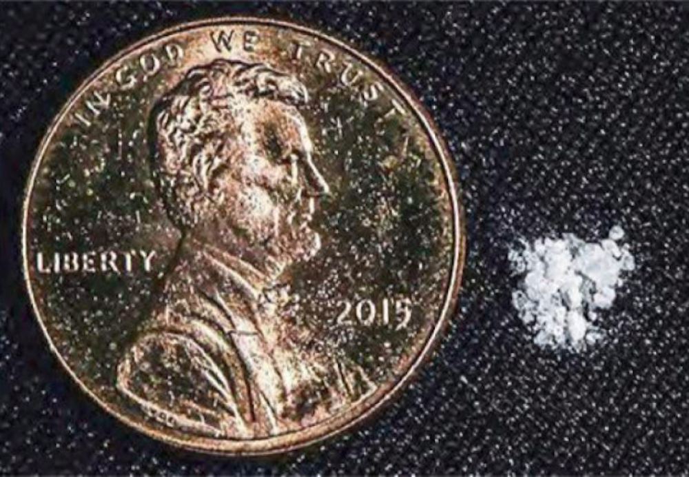 a penny next to an ounce of fentanyl