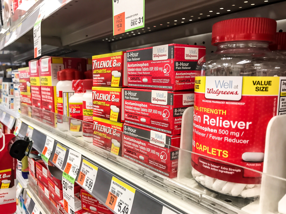 Drug store shelf  filled with tylenol and other pain relievers.