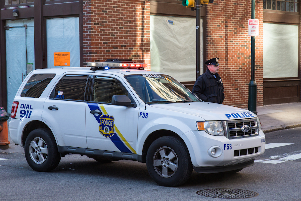 A Philadelphia police officer standing beside his vehicle