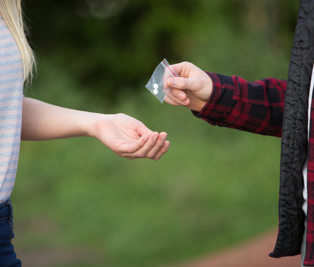 a een girl buying pills from a dealer
