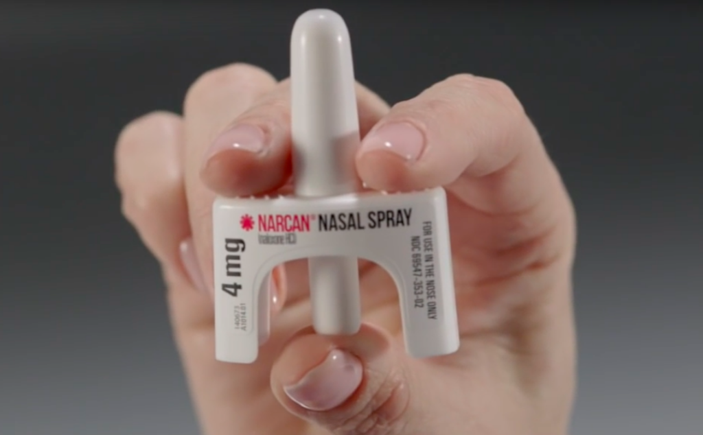 woman holding Narcan nasal spray