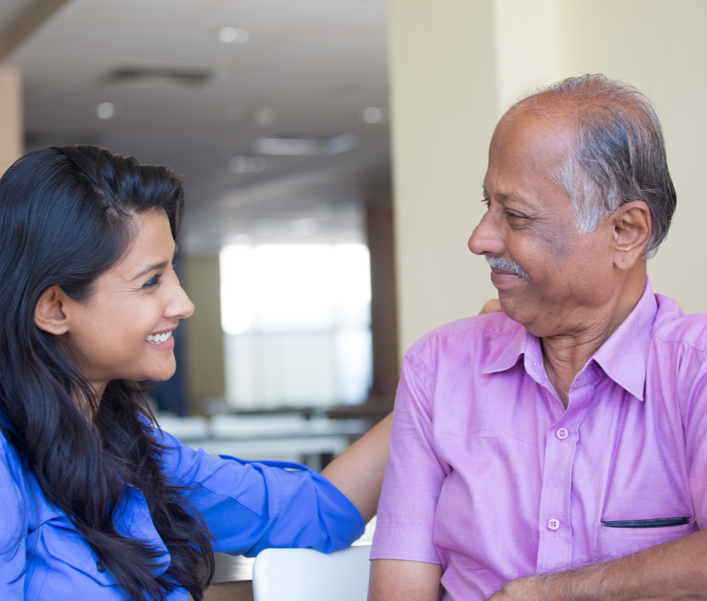 young woman in blue shirt affectionately gazing at older man.