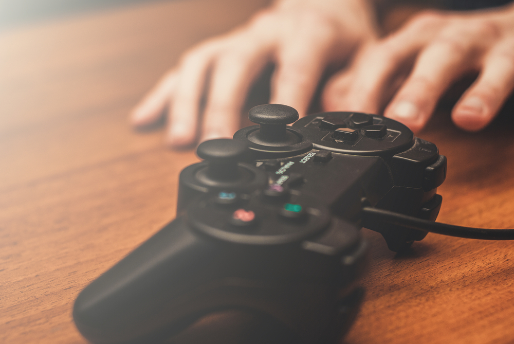 Hands reaching for a video game controller.